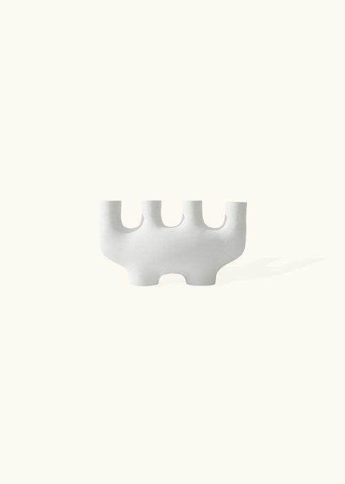 the "Amoeba" ceramic candlestick: another unique addition to our collection. Crafted from pristine white ceramic, this candlestick measures W21.5 x 12cm, featuring an intriguing shape that adds a touch of whimsy and sophistication to your decor