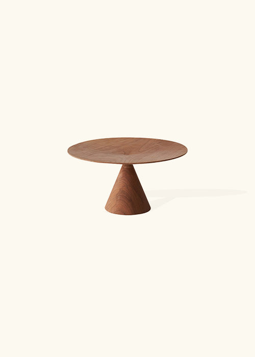 A beautifully crafted cake stand made from rich cherry wood. The stand features a cone-shaped base and a flat, disc-shaped top serving as a platform for showcasing delectable cakes. The warm, natural tones of the cherry wood enhance the elegance of this piece, making it an exquisite addition to your dessert presentation and a perfect complement to any occasion