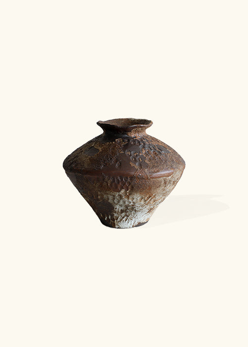 short burnt pot, reminiscent of ancient artifacts with its weathered appearance and captivating "Burnt" color