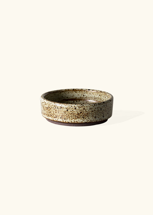 Handmade stone flat dish, measuring W9.2cm x H3cm. Featuring a rugged yet sleek style, this dish is part of a comprehensive set of raw pottery dishes and mugs designed for versatile dining needs.