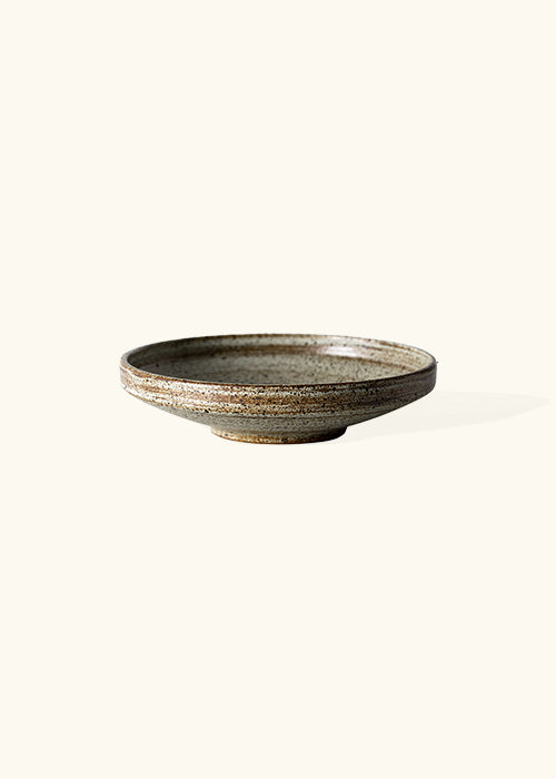 Handmade stone wide bowl, measuring W21.3cm x H5cm. Featuring a rugged yet sleek style, this bowl is part of a comprehensive set of raw pottery dishes and mugs designed for versatile dining needs.