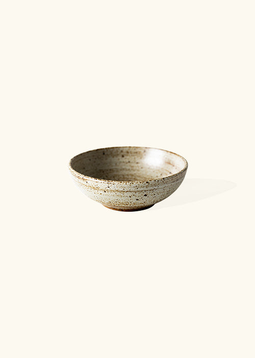 Handmade stone round bowl, measuring W12.5cm x H4.5cm. Featuring a rugged yet sleek style, this bowl is part of a comprehensive set of raw pottery dishes and mugs designed for versatile dining needs