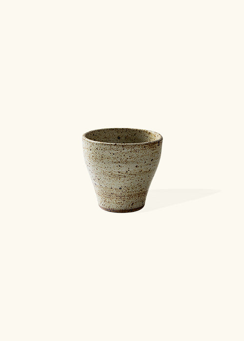 Handmade stone tapered mug, measuring W8cm x H7.5cm. Exhibiting a rugged yet sleek style, this mug is part of a comprehensive set of raw pottery dishes and mugs designed for versatile dining needs.